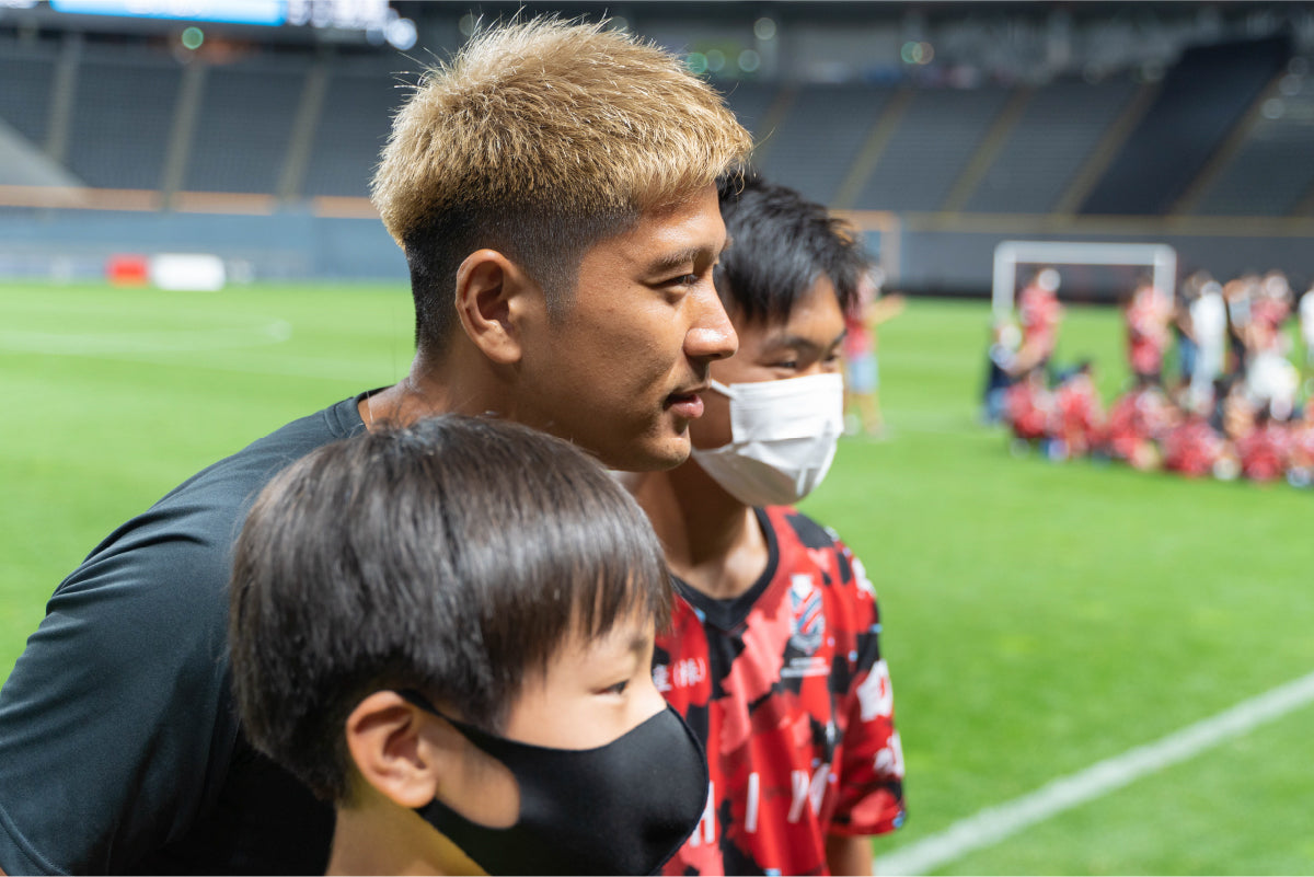 子供と記念撮影する選手