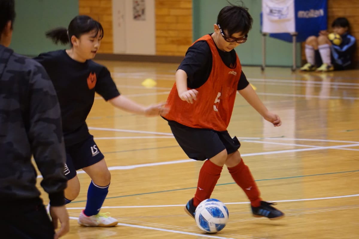 体育館でサッカーをする子供達